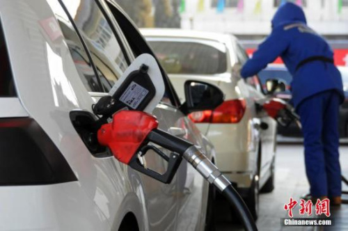 资料图：山西太原，加油站工作人员给汽车加油