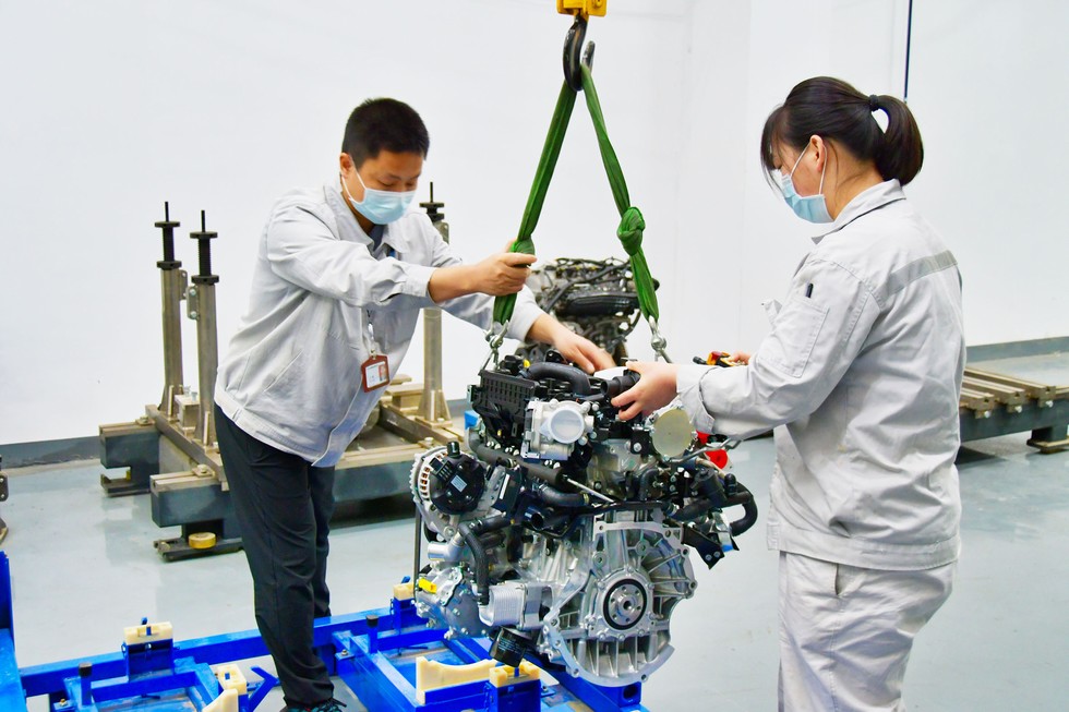 项目组成员在搬运发动机